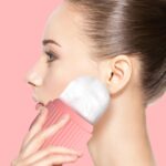 Close-up of the pink striped Joyeee silicone ice facial roller, ready for use on skin.